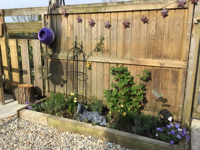 Mojo’s likit holder, solar lights and stone pony and foal used to decorate a new plant border for her memorial garden