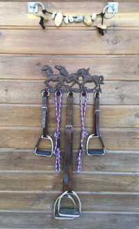 A display of Mojo’s old stirrups hung on a runnng pony / horse bar and some lucky stones taken from the beach